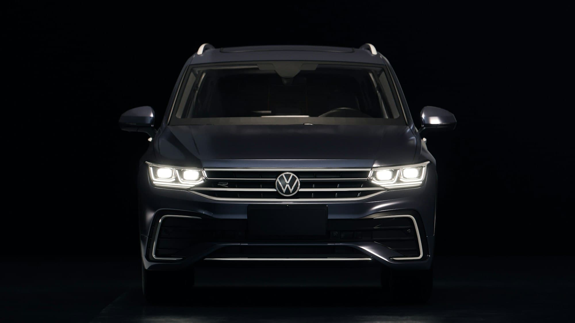 SUV with headlights on against a dark background